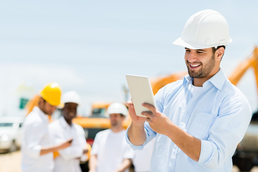 Männlicher Ingenieur auf einer Baustelle mit einem Tablet-Computer