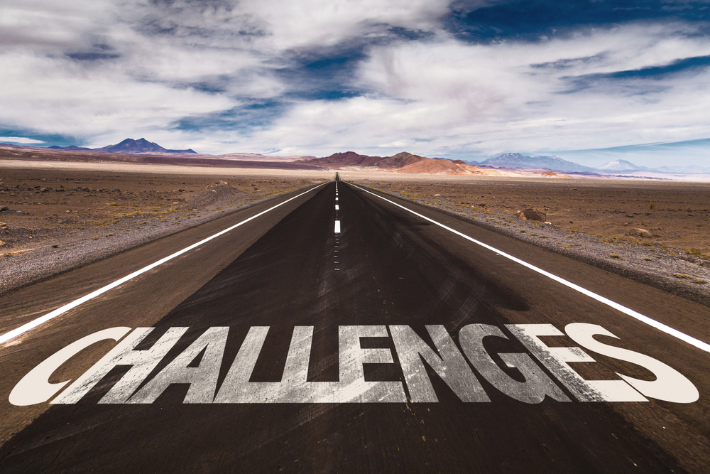 Challenges“ auf einer endlosen Straße in einer Wüstenlandschaft – Symbol für komplexe Projektanforderungen im Anlagenbau, Lieferantenkoordination, Ressourcenmanagement und digitale Transformation im Projektmanagement.