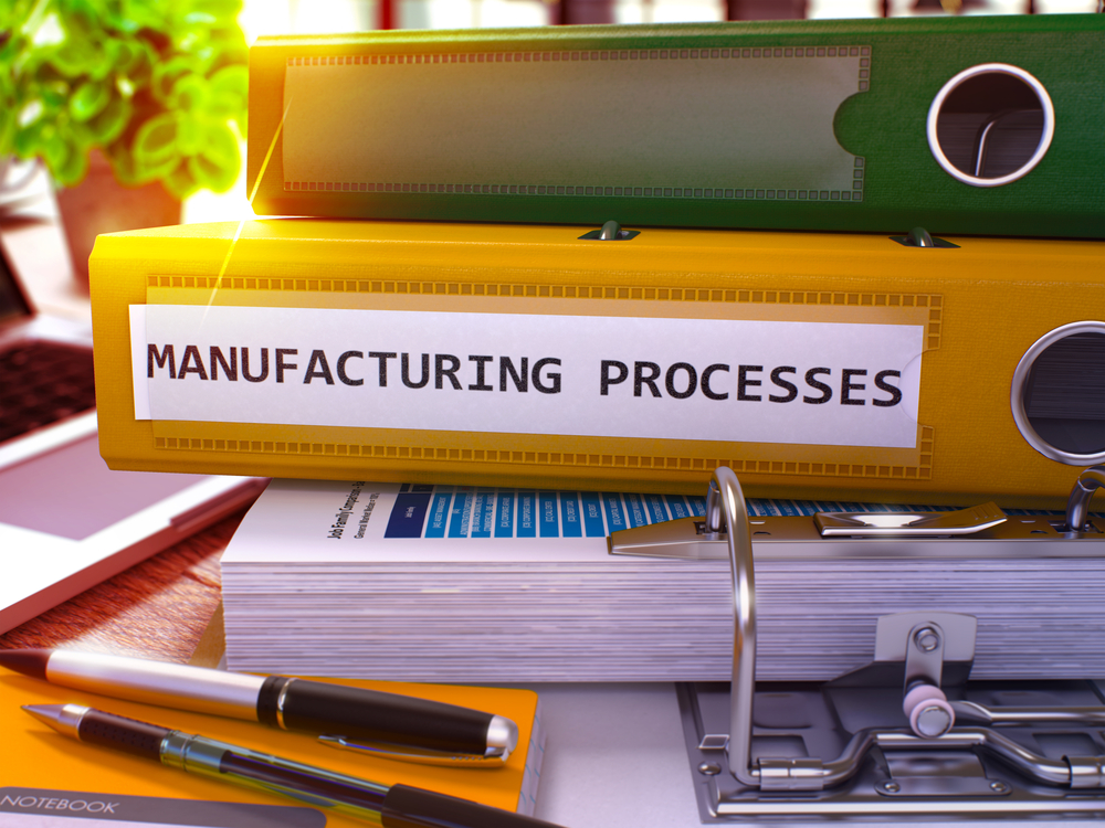 Yellow ring binder with inscription against the background of a desk with office supplies and laptop. Depiction of manufacturing processes against a blurred background. 3D rendering.