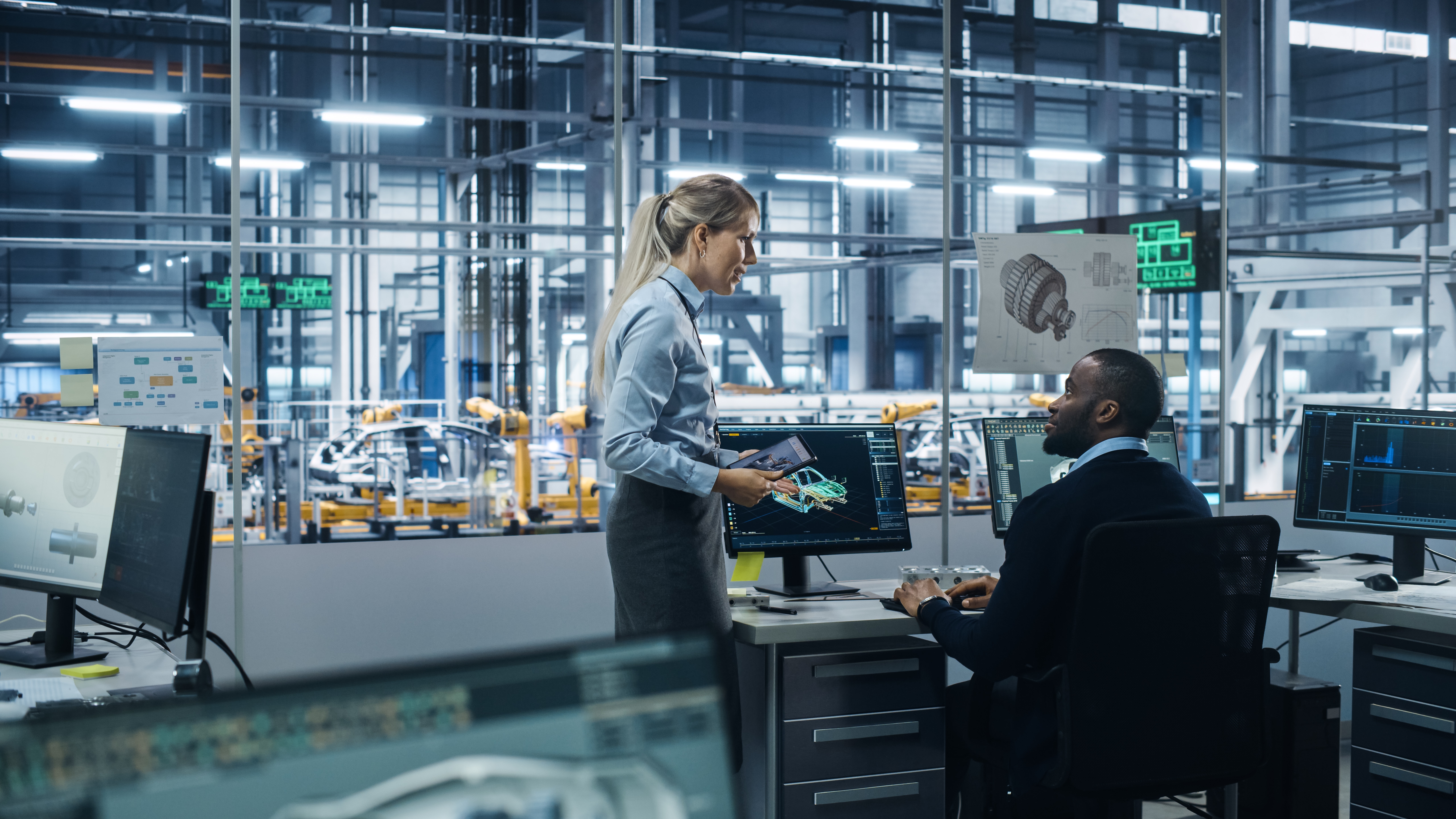 Project team in automotive plant engineering analyzes production data and coordinates project control measures on the production line.
